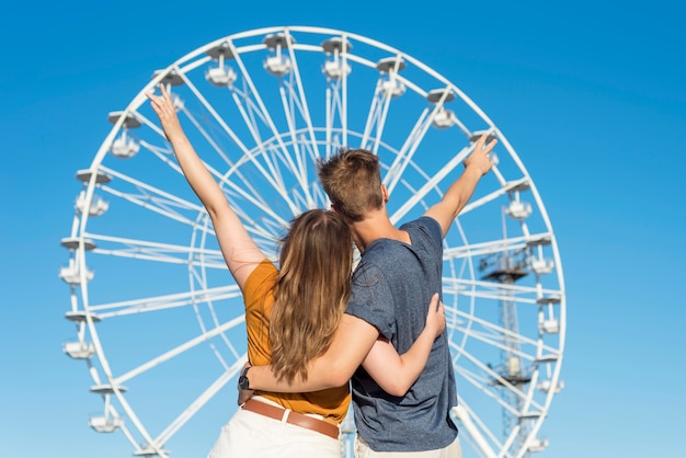 Vue arrière couple regardant une roue amusante