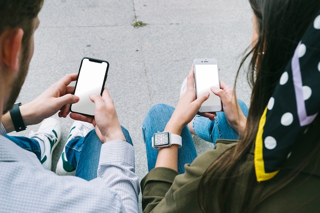 Vue arrière d&#39;un couple utilisant un smartphone