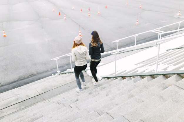 Vue arrière de deux femmes jogging sur l&#39;escalier en hiver