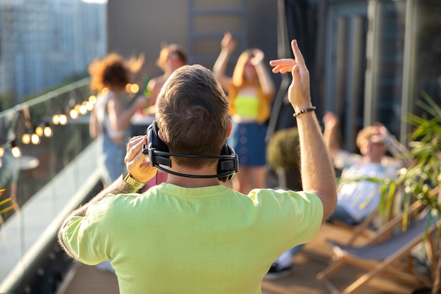 Photo gratuite vue arrière dj portant des écouteurs