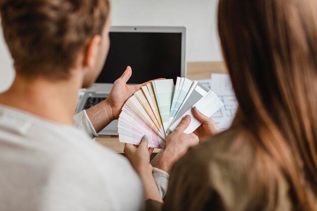 Vue arrière du couple faisant des plans pour remodeler la maison ensemble