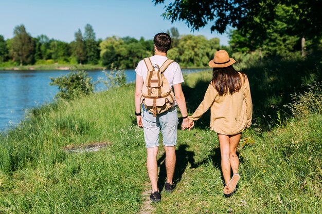 Vue arrière du couple marchant près du lac