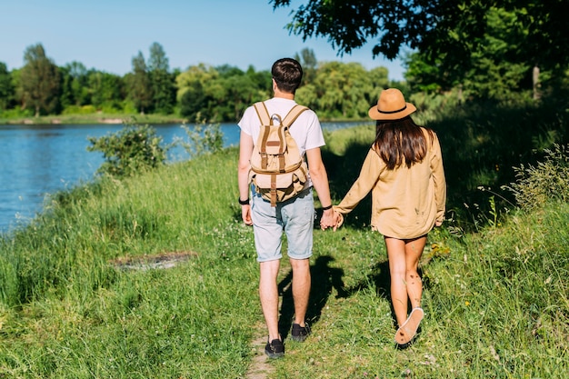 Vue arrière du couple marchant près du lac