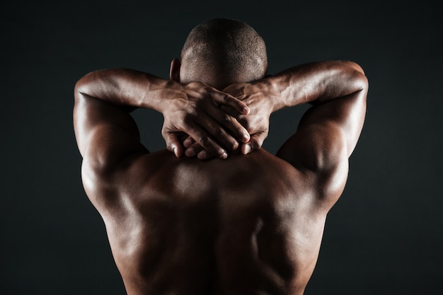 Photo gratuite vue arrière du jeune homme africain avec un corps musclé tenant son cou