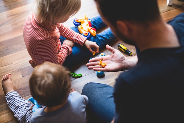 Vue arrière du père jouant avec ses enfants