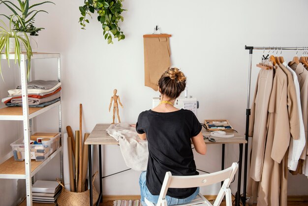 Vue arrière du tailleur féminin travaillant dans le studio