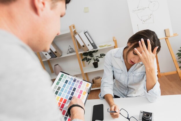 Vue arrière épuisée femme assise à son bureau