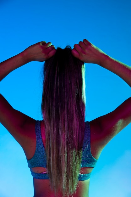 Photo gratuite vue arrière de la femme attachant ses cheveux