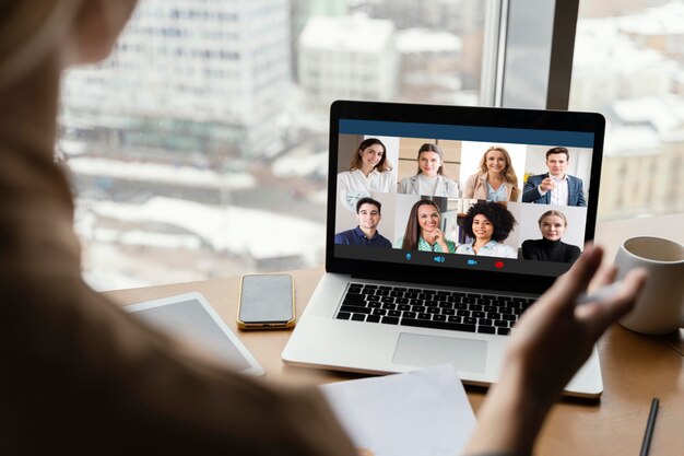 Vue arrière de la femme ayant un appel vidéo au travail