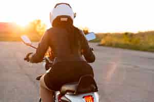Photo gratuite vue arrière de la femme avec casque sur sa moto