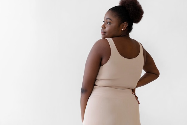 Vue arrière de la femme confiante posant tout en portant un body shaper