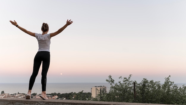 Vue arrière femme debout de manière victorieuse avec copie espace