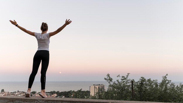 Vue arrière femme debout de manière victorieuse avec copie espace