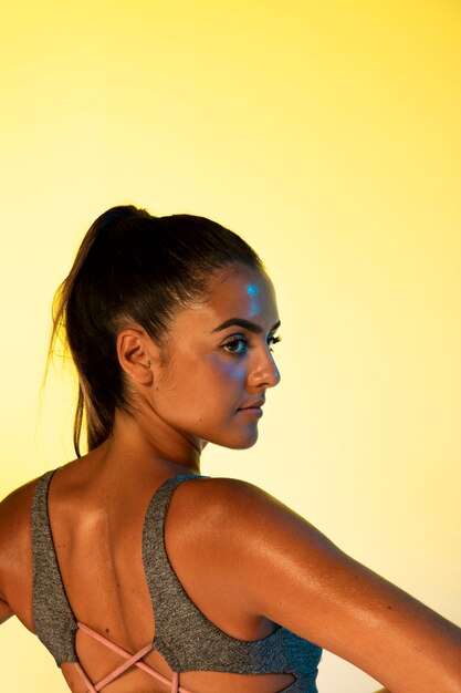 Photo gratuite vue arrière de la femme avec un fond jaune