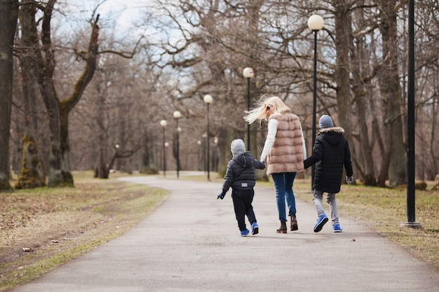 Vue arrière d&#39;une femme marchant avec ses enfants