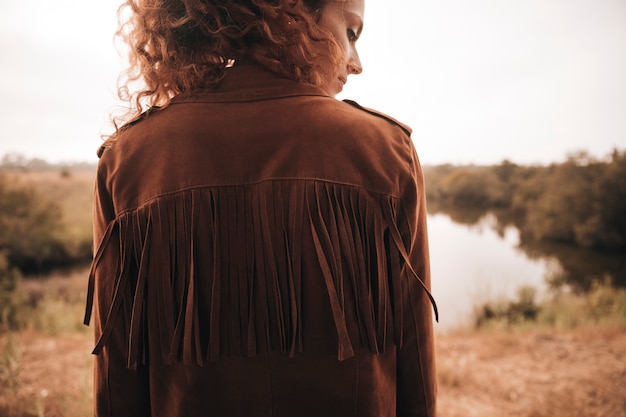 Photo gratuite vue arrière femme posant à côté d'un étang