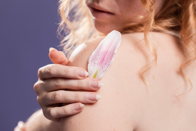 Vue arrière d'une femme posant avec un pétale de fleur