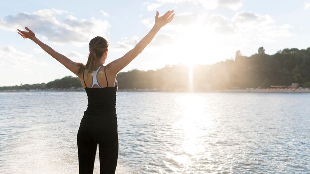 Vue arrière femme profitant de la lumière du soleil