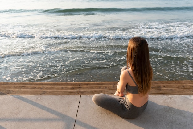 Vue arrière femme regardant la mer avec espace copie