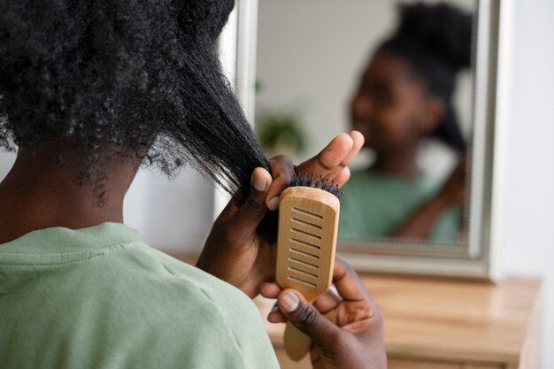 Vue arrière femme se brosser les cheveux