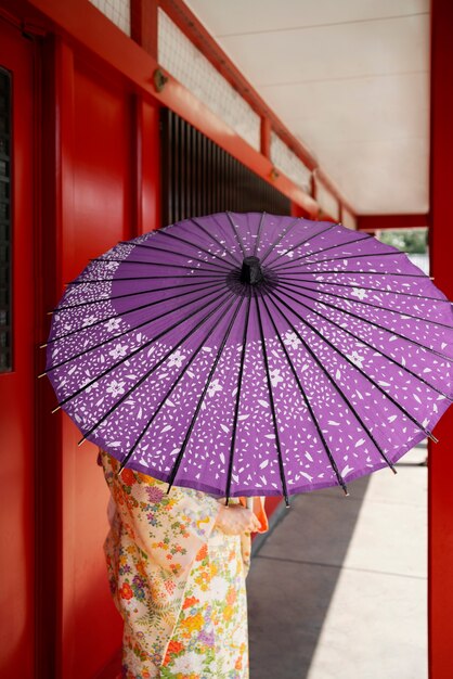 Vue arrière femme tenant un parapluie wagasa