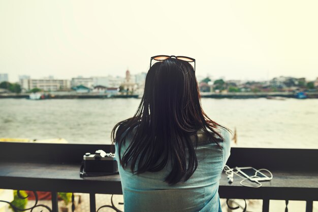 Vue arrière de la femme de tourisme asiatique assis au bord de la rivière