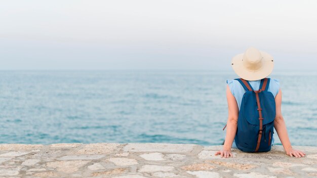 Vue arrière de la femme touriste âgée appréciant la vue sur l'océan