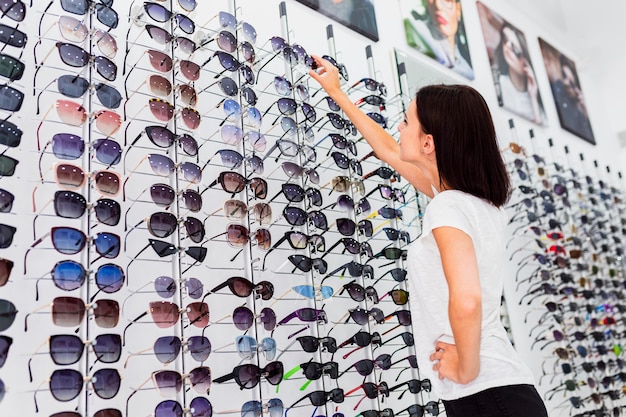 Vue arrière d'une femme vérifiant ses lunettes de soleil