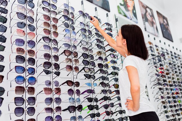 Vue arrière d'une femme vérifiant ses lunettes de soleil