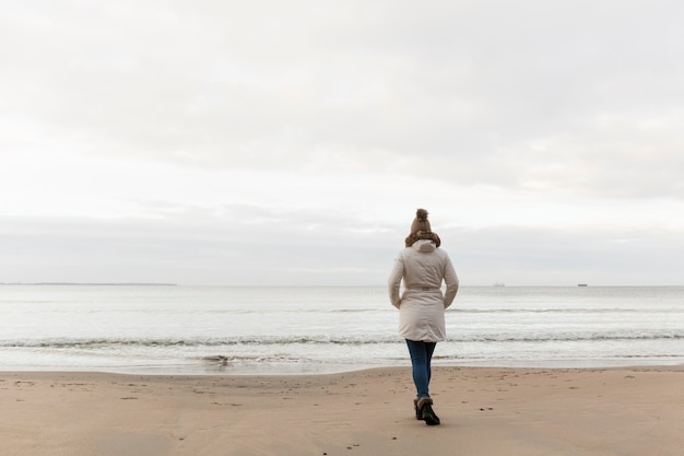 Photo gratuite vue arrière femme walkingon shore