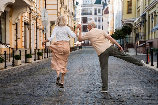 Vue arrière de l'heureux couple de personnes âgées dans la ville