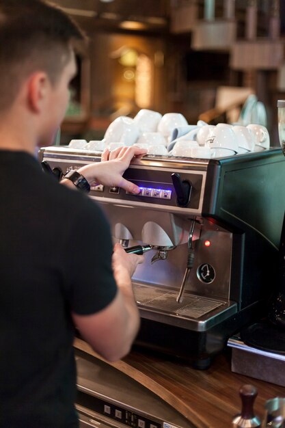 Vue arrière homme à l&#39;aide de la machine à café