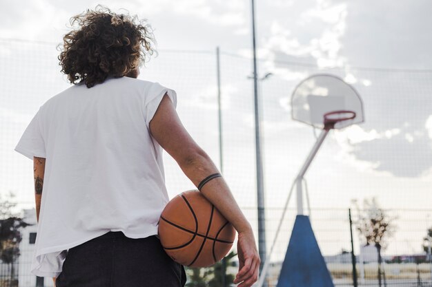 Vue arrière d&#39;un homme avec un ballon de basket