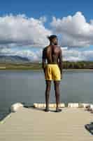 Photo gratuite vue arrière homme debout au bord du lac