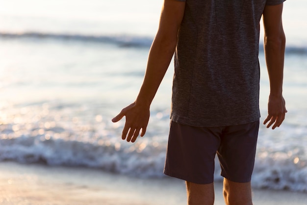 Photo gratuite vue arrière homme debout à côté de la mer