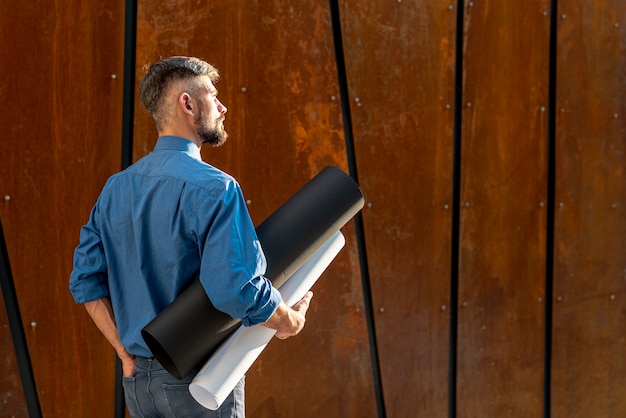 Photo gratuite vue arrière de l'homme avec plan de construction