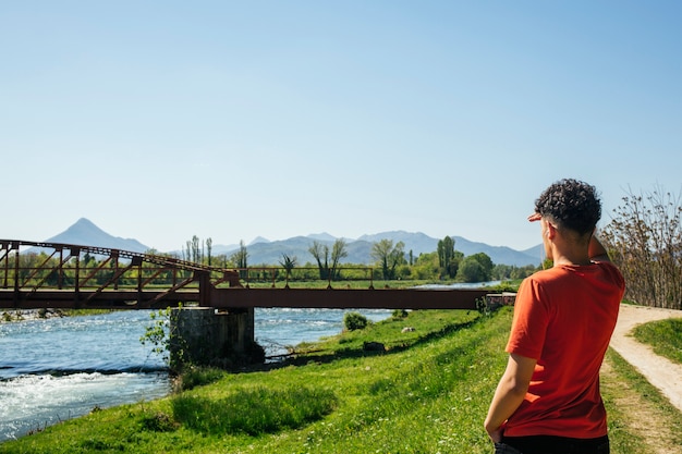 Photo gratuite vue arrière de l'homme protégeant ses yeux en regardant la belle nature