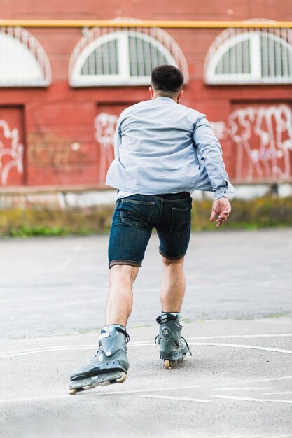 Photo gratuite vue arrière d'un homme rollerskating à l'extérieur
