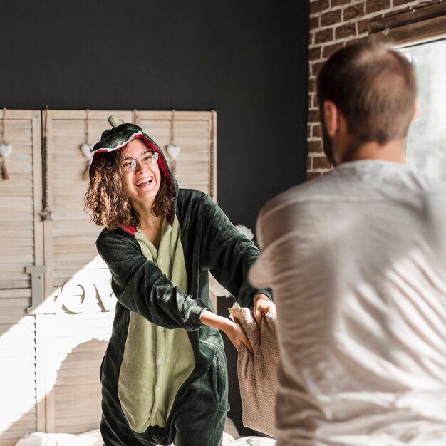 Vue arrière d&#39;un homme se moquer de sa femme à la maison