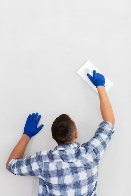 Vue arrière de l'homme travaillant sur le mur avec copie espace