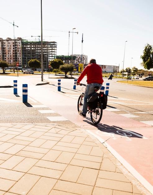 Vue arrière d&#39;un homme à vélo sur la rue dans la ville