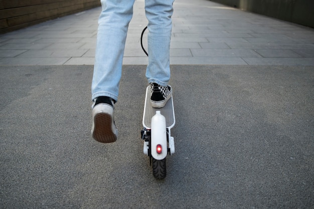 Vue arrière jeune sur scooter électrique