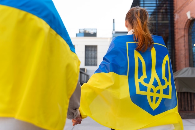 Vue arrière des personnes portant des drapeaux ukrainiens