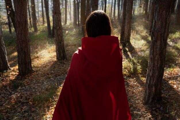 Vue arrière petit chaperon rouge dans la forêt