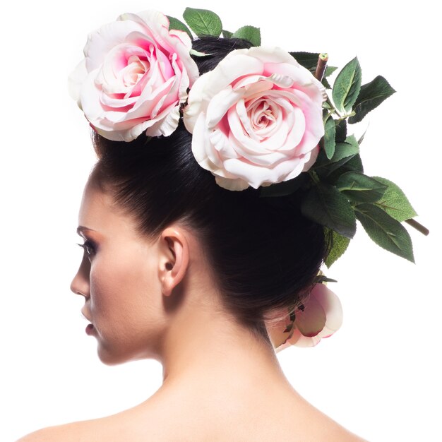 Photo gratuite vue arrière portrait de la femme avec des fleurs roses dans les cheveux - isolé sur blanc