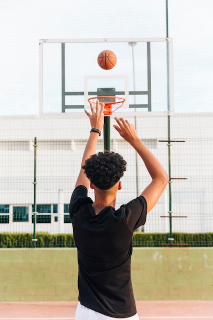 Vue arrière, de, sportif, lancer balle, dans, cerceau