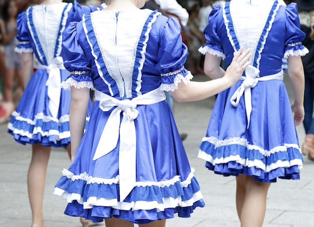 Vue arrière de trois jeunes femmes portant l'un des costumes folkloriques des états-unis
