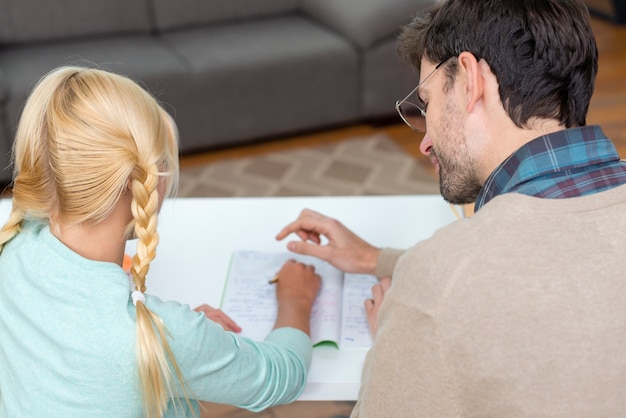 De la vue arrière tuteur et fille travaillant