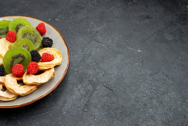 Vue Avant Des Anneaux D'ananas Séchés Avec Des Kiwis Et Des Pommes Séchées Sur La Surface Gris Foncé Fruits Bonbons De Sucre Sucré Sec