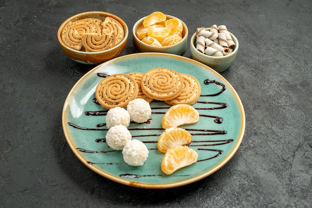 Vue avant des biscuits sucrés avec des bonbons à la noix de coco sur le bureau gris biscuit biscuit sweet